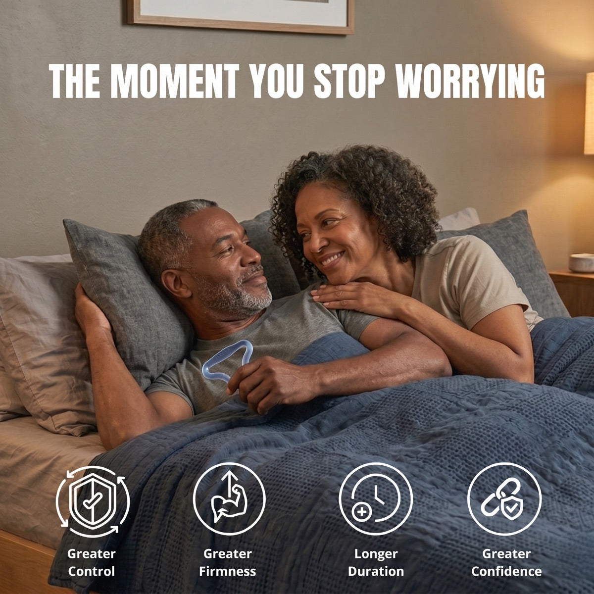 The moment you stop worrying: a couple in bed, the man holding the slate blue Sedgeia ring