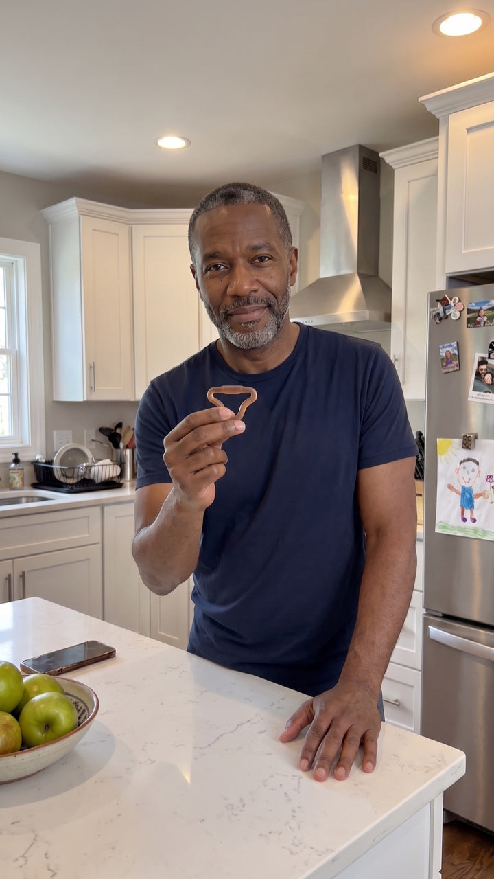 Man in his kitchen holding a Firm Sedgeia ring between two fingers