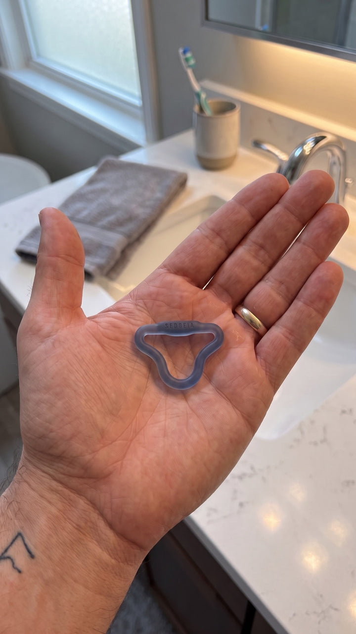 Intense Sedgeia ring resting in a man's open palm, showing its small size