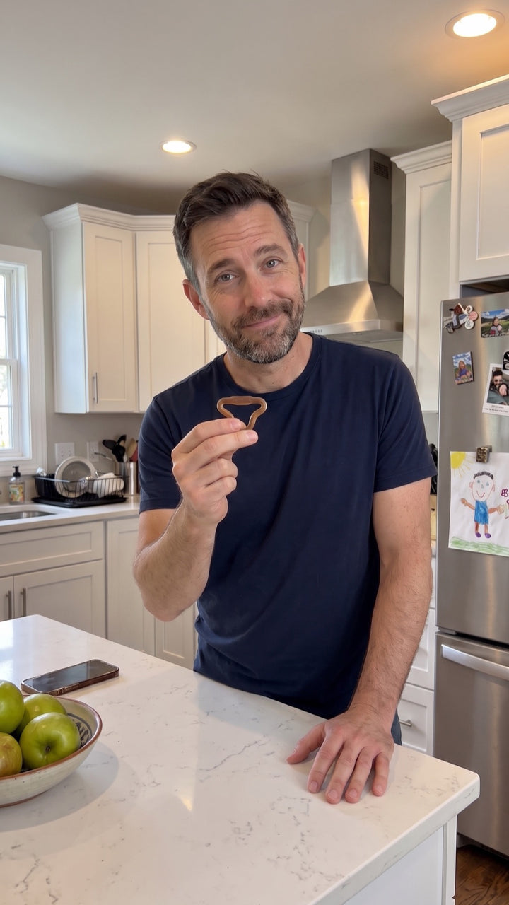 Man in his kitchen holding a Firm Sedgeia ring between two fingers