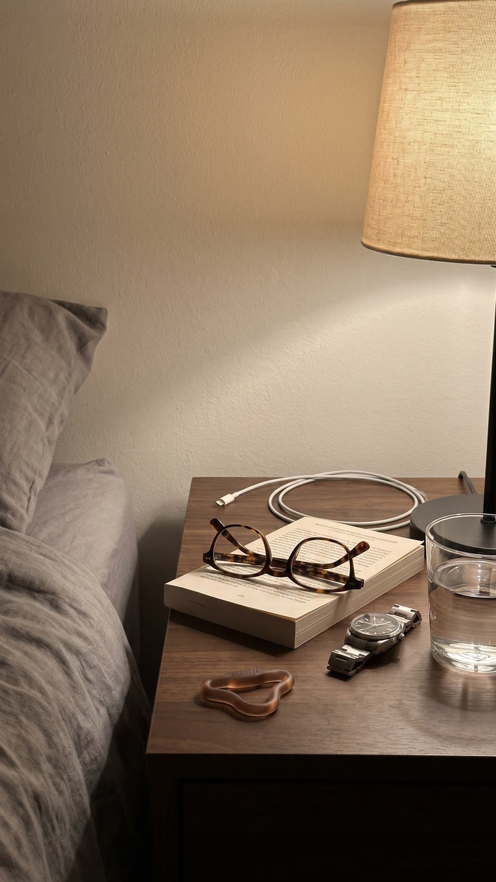 Firm Sedgeia ring on a nightstand beside reading glasses, a watch and a glass of water