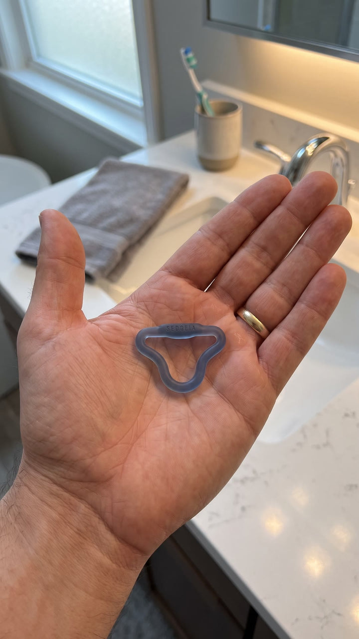 Intense Sedgeia ring resting in a man's open palm, showing its small size